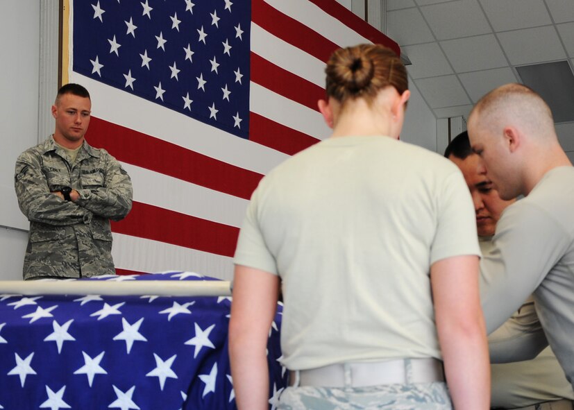 Senior Airman Joel Carey, 319th Air Base Wing Honor Guard ceremonial guardsman, supervises new members of the honor guard July 8, 2015 during a six-man flag fold practice on Grand Forks Air Force Base, N.D. Carey was named warrior of the week for the second week of July 2015. (U.S. Air Force Photo by Senior Airman Zachiah Roberson/released)