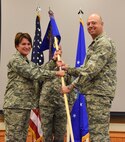 Lt. Col. Joel Purcell, right, accepts command of the 341st Civil Engineer Squadron from Col. Denise Cooper, 341st Mission Support group commander, during a change of command ceremony at the Malmstrom Air Force Base Grizzly Bend July 9. Master Sgt. Robert Taylor, 341st CES first sergeant, looks on. (U.S. Air Force photo/Airman 1st Class Collin Schmidt)