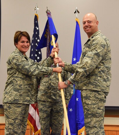 Lt. Col. Joel Purcell, right, accepts command of the 341st Civil Engineer Squadron from Col. Denise Cooper, 341st Mission Support group commander, during a change of command ceremony at the Malmstrom Air Force Base Grizzly Bend July 9. Master Sgt. Robert Taylor, 341st CES first sergeant, looks on. (U.S. Air Force photo/Airman 1st Class Collin Schmidt)
