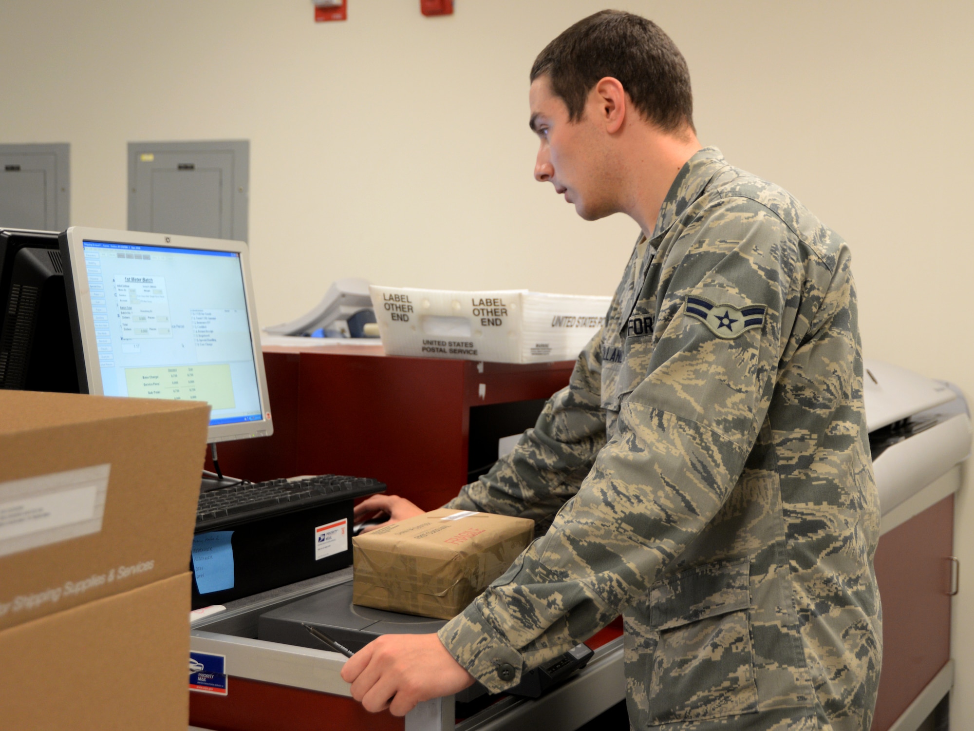 Airman 1st Class Ryan Holland, postal apprentice, prepares a consolidated package June 24, 2015, Scott Air Force Base, Illinois. Holland was one of the Airmen that helped streamline the program helping save the official mail center money. (U.S. Air Force photo by Airman 1st Class Melissa Estevez)