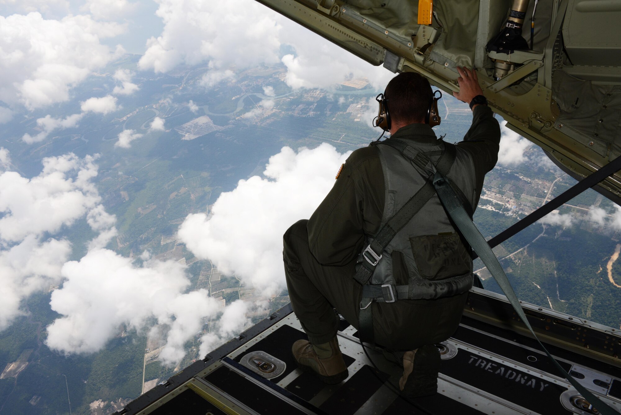 Tech. Sgt. Nicholas Sealy, a loadmaster from the 17th Special Operations Squadron, looks over the drop zone during a high-altitude low-opening personnel drop June 8, 2015 near Kuantan, Malaysia. The high-altitude low-opening jumps were conducted as part of Exercise Teak Mint, a multinational and bilateral exercise between the Royal Malaysian Air Force and the U.S. Air Force. (U.S. Air Force photo by Tech. Sgt. Kristine Dreyer) 
