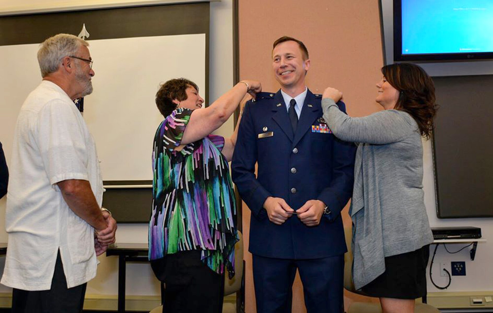 Col. Timothy Michel, 55th Aerial Port Squadron commander, pins on his O-6 rank June 21, 2015 at the Aerial Port Squadron building on Travis Air Force Base. (U.S. Air Force photos/Senior Airman Madelyn Brown)
