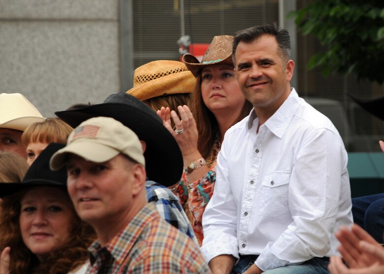 Col. Anthony J. Mastalir, 50th Space Wing vice commander, and his wife, Danielle, watch as the Pikes Peak or Bust Rodeo parade passes the grand stand in downtown Colorado Springs, Colorado Tuesday, July 7, 2015. This year marks the 75th anniversary for the Pikes Peak or Bust Rodeo which takes place July 8-11. (U.S. Air Force photo/Staff Sgt. Debbie Lockhart)