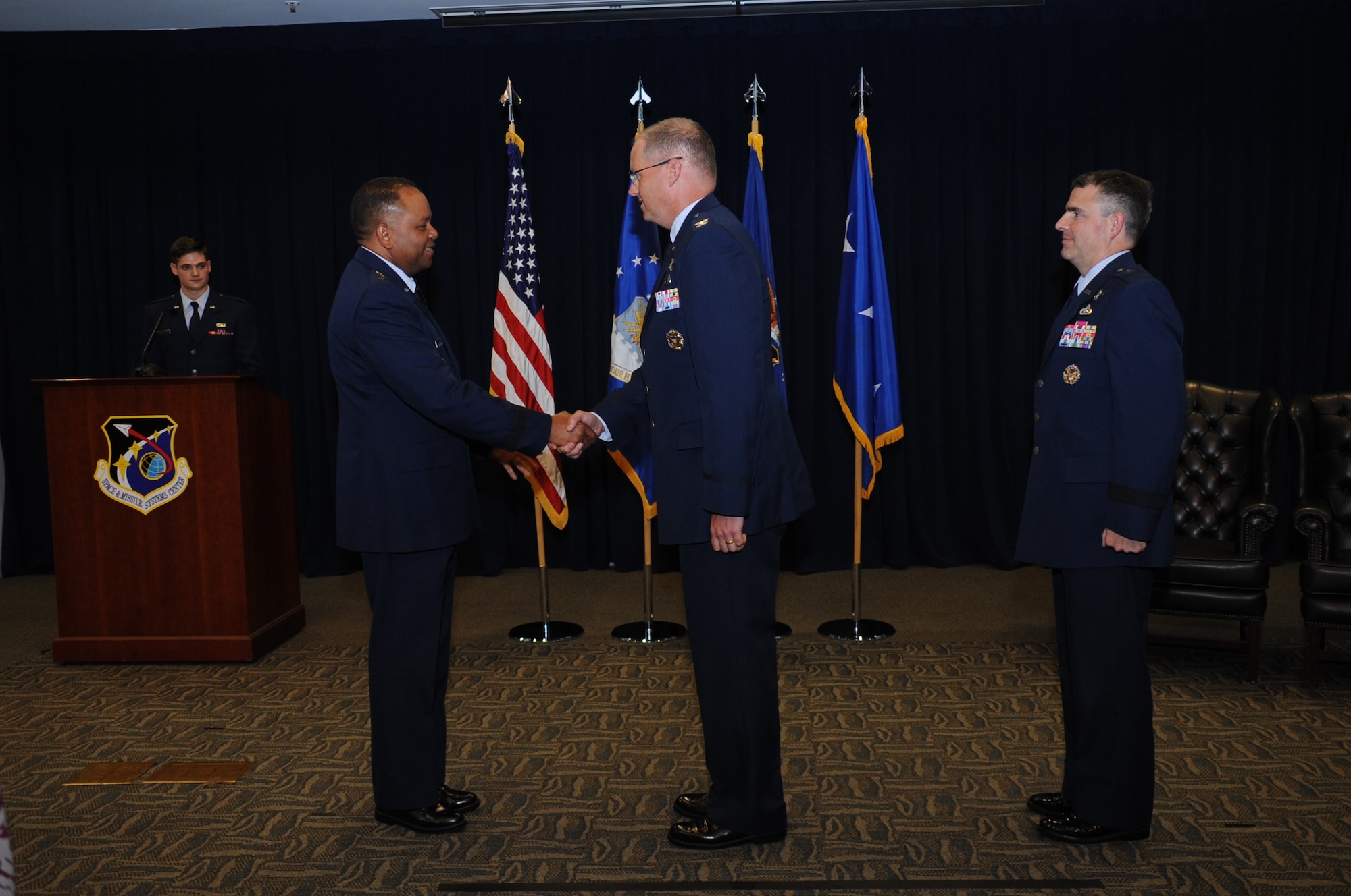 Lt. Gen. Samuel Greaves, presiding official and commander of Air Force Space Command's Space and Missile Systems Center at Los Angeles Air Force Base, Calif., congratulates Col. Steven Whitney on accepting the reins of responsibility as incoming director of the Global Positioning Systems Directorate during a change of leadership ceremony July 8 in the Gordon Conference Center. Whitney succeeds Brig. Gen. William Cooley, the outgoing director, who leaves for his new assignment at the Redstone Arsenal in Huntsville, Alabama with the Missile Defense Agency after leading the GP Directorate at SMC for the past two years. (U.S. Air Force photo/ Van Ha)