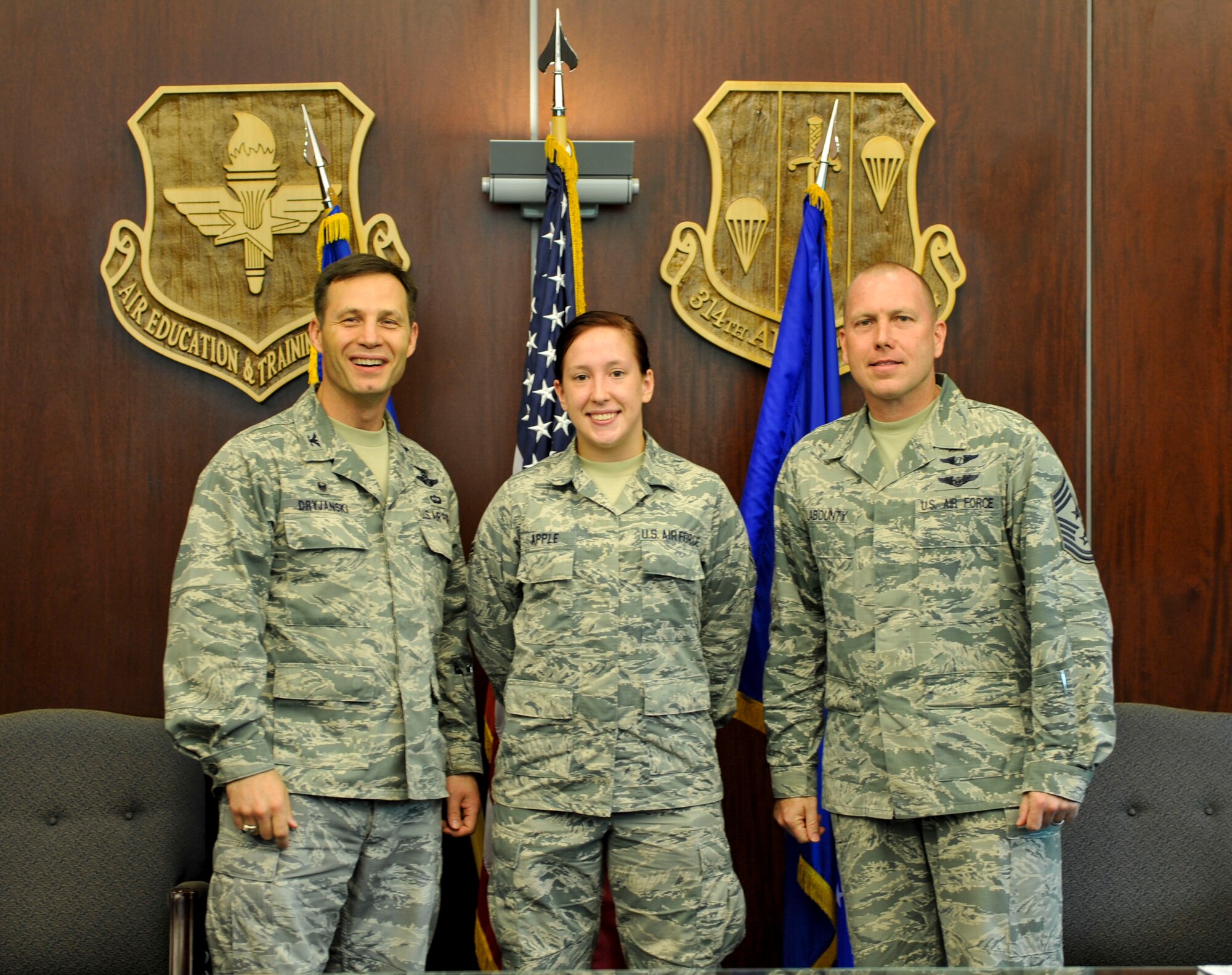 Col. James Dryjanski, 314th Airlift Wing commander, along with Chief Master Sgt. Brian Labounty, 314th Airlift Wing command chief, congratulate Airman 1st Class Justine Apple, a 314th Aircraft Maintenance Squadron apprentice, on her selection as Combat Airlifter of the Week July 8, 2015, at Little Rock Air Force Base, Ark. Apple is a vital team member who monitors and coordinates maintenance actions on 18 C-130H aircraft supporting initial and advanced aircrew training.  (U.S. Air Force photo by Senior Airman Stephanie Serrano)