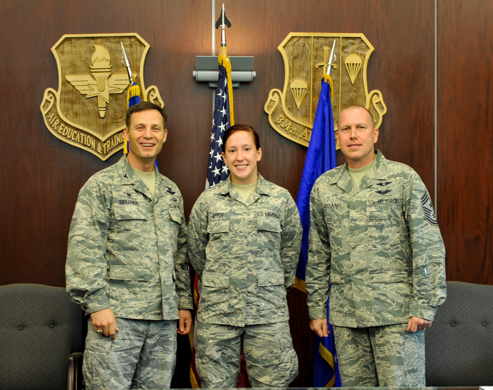 Col. James Dryjanski, 314th Airlift Wing commander, along with Chief Master Sgt. Brian Labounty, 314th Airlift Wing command chief, congratulate Airman 1st Class Justine Apple, a 314th Aircraft Maintenance Squadron apprentice, on her selection as Combat Airlifter of the Week July 8, 2015, at Little Rock Air Force Base, Ark. Apple is a vital team member who monitors and coordinates maintenance actions on 18 C-130H aircraft supporting initial and advanced aircrew training.  (U.S. Air Force photo by Senior Airman Stephanie Serrano)