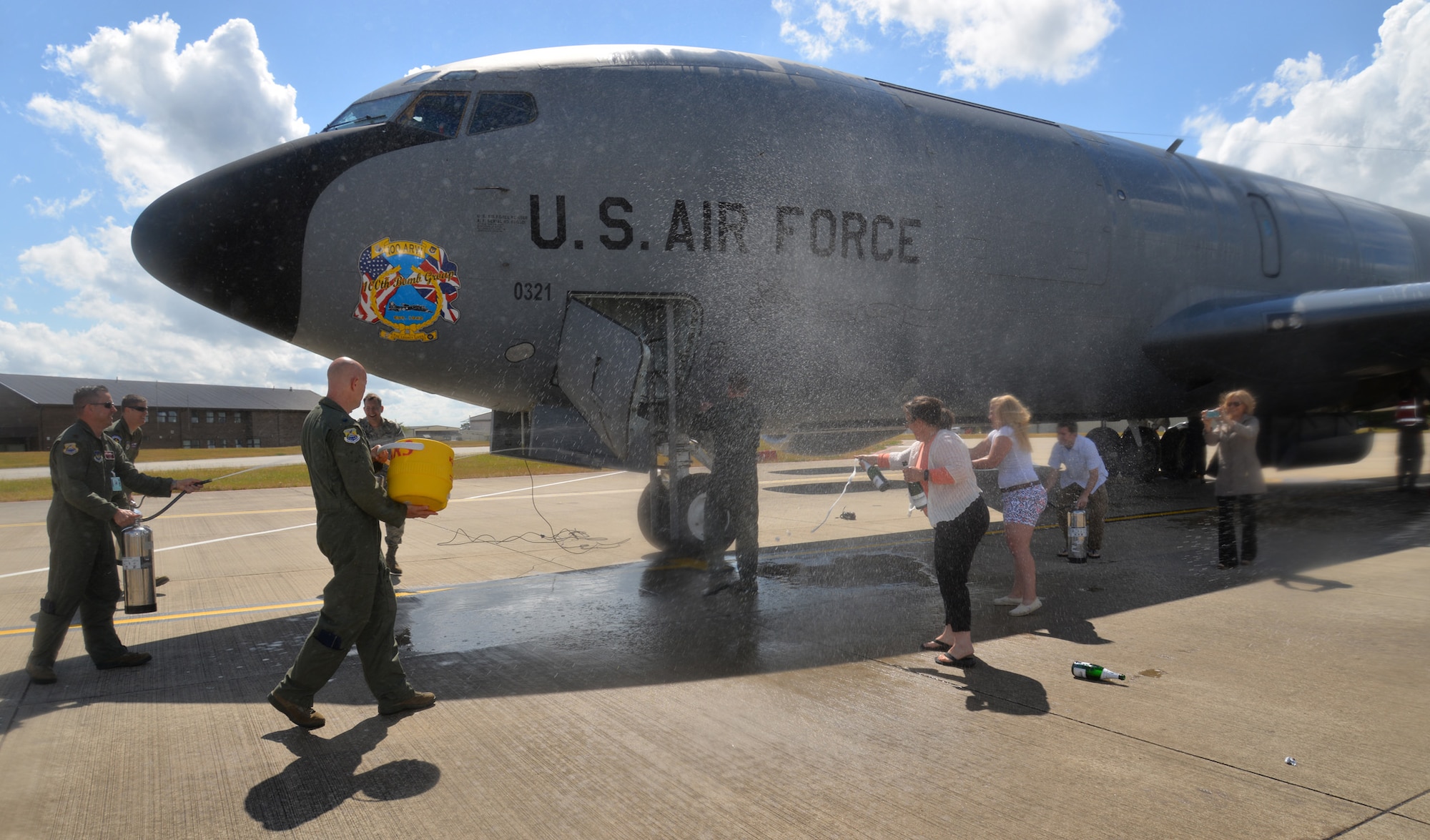 U.S. Air Force Col. David Cox, center, 100th Air Refueling Wing vice commander, is sprayed with water from all directions as part of his “fini-flight” July 7, 2015, on RAF Mildenhall, England. Cox’s family, friends and Team Mildenhall members took turns dousing him with water as part of fini-flight traditions commemorating his time as vice commander. (U.S. Air Force photo by Karen Abeyasekere/Released)