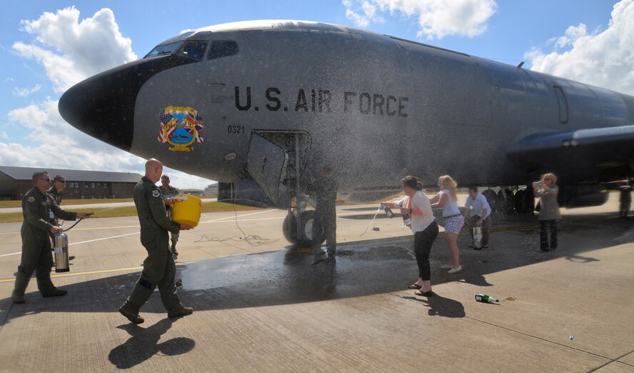 U.S. Air Force Col. David Cox, center, 100th Air Refueling Wing vice commander, is sprayed with water from all directions as part of his “fini-flight” July 7, 2015, on RAF Mildenhall, England. Cox’s family, friends and Team Mildenhall members took turns dousing him with water as part of fini-flight traditions commemorating his time as vice commander. (U.S. Air Force photo by Karen Abeyasekere/Released)