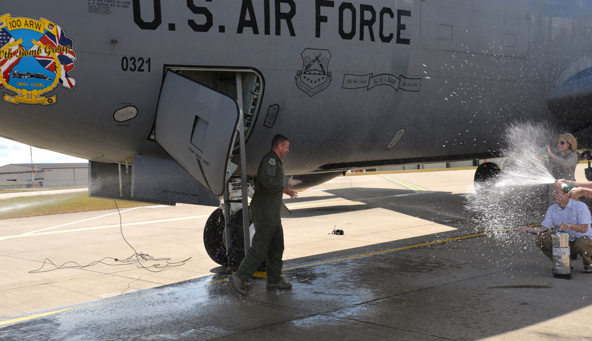 U.S. Air Force Col. David Cox, left, 100th Air Refueling Wing vice commander, is sprayed with water from all directions as part of his “fini-flight” July 7, 2015, on RAF Mildenhall, England. Cox’s family, friends and Team Mildenhall members took turns dousing him with water as part of fini-flight traditions commemorating his time as vice commander. (U.S. Air Force photo by Karen Abeyasekere/Released)