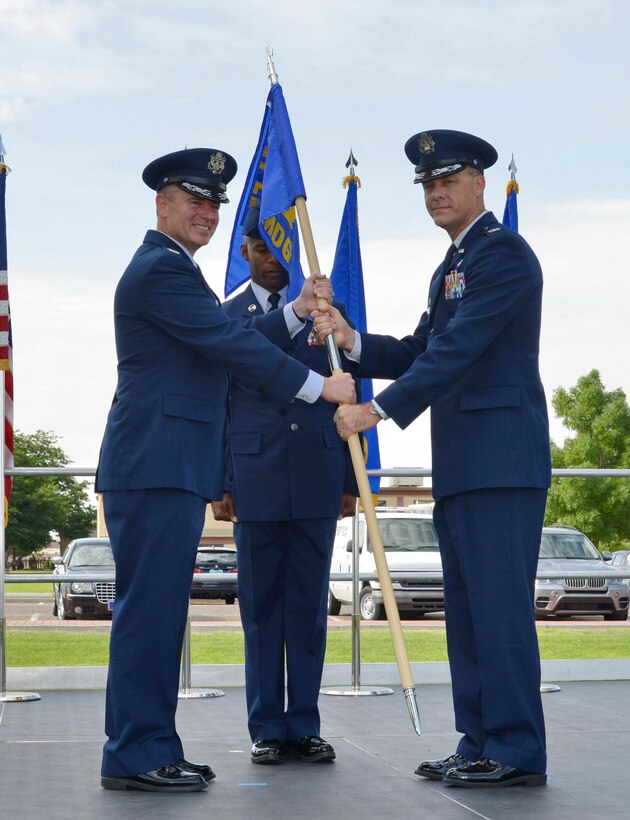 Col. Eric Froehlich (left), 377th Air Base Wing commander, passes the 377th Medical Group guidon to Col. Jeffrey White at a change of command ceremony July 2.  White assumed command of the group at the ceremony, replacing former commander Col. Rachel Lefebvre. (Photo by Jamie Burnett)