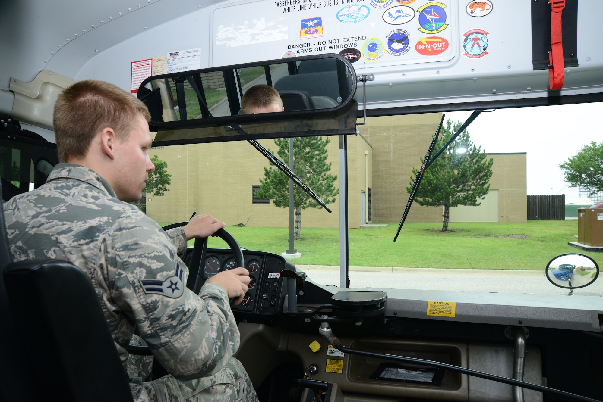 Airman 1st Class Weston Huffer, 22nd Logistics Readiness Squadron vehicle operator, checks his side mirror on his way to an air refueling squadron, July 7, 2015, McConnell Air Force Base, Kan. Vehicle operations Airmen transport aircrews to aircraft so they can begin their mission and return aircrews to their squadrons after mission completion. (U.S. Air Force photo by Airman 1st Class Christopher Thornbury)