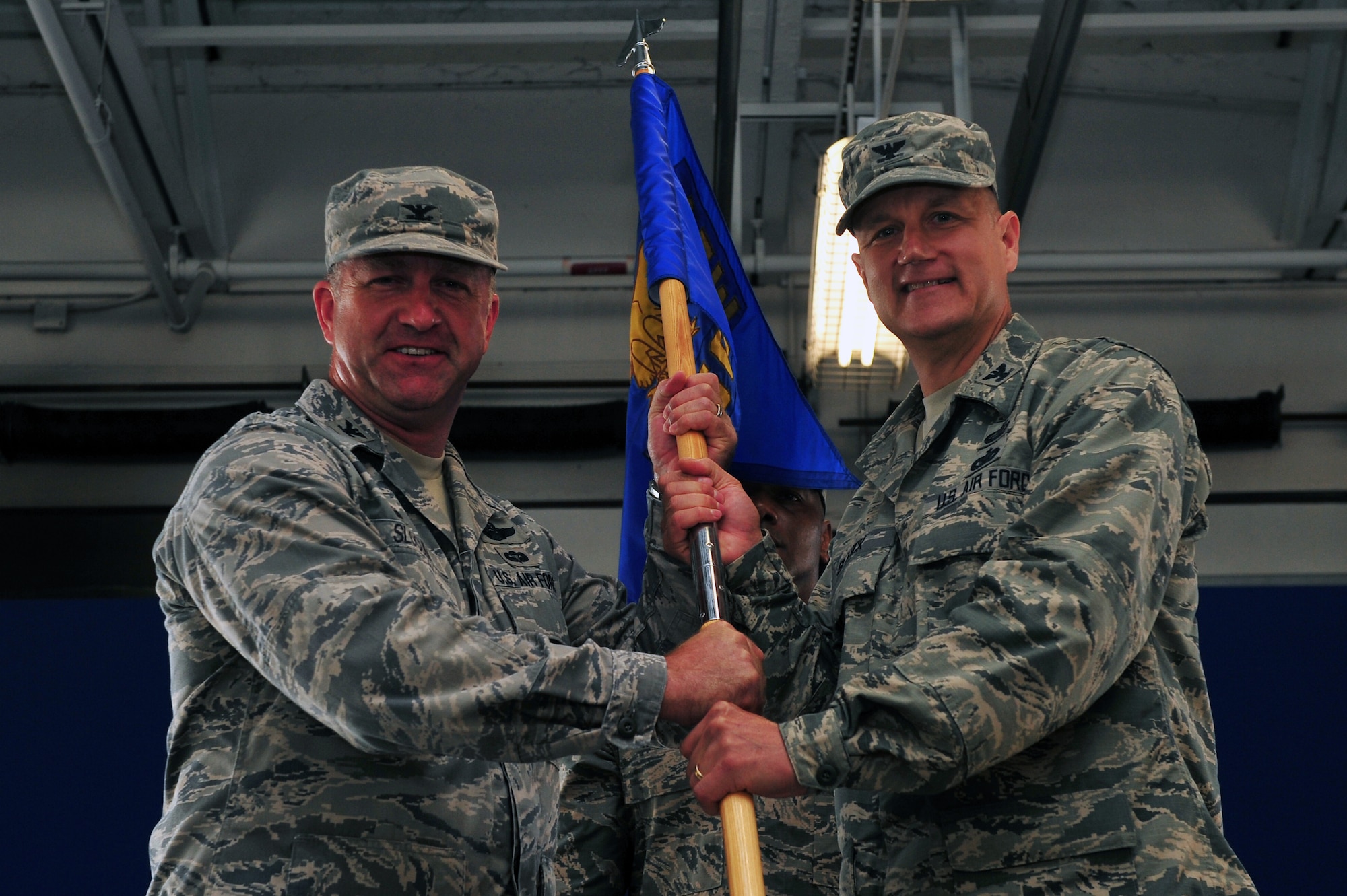 Col. Mark Slocum, 4th Fighter Wing commander, passes the guidon to Col. Joe Slavick, incoming 4th Mission Support Group commander, during the 4th MSG assumption of command ceremony, July 8, 2015, at Seymour Johnson Air Force Base, North Carolina. The 4th MSG is comprised of six squadrons performing various support functions. U.S. Air Force photo/Senior Airman John Nieves Camacho)