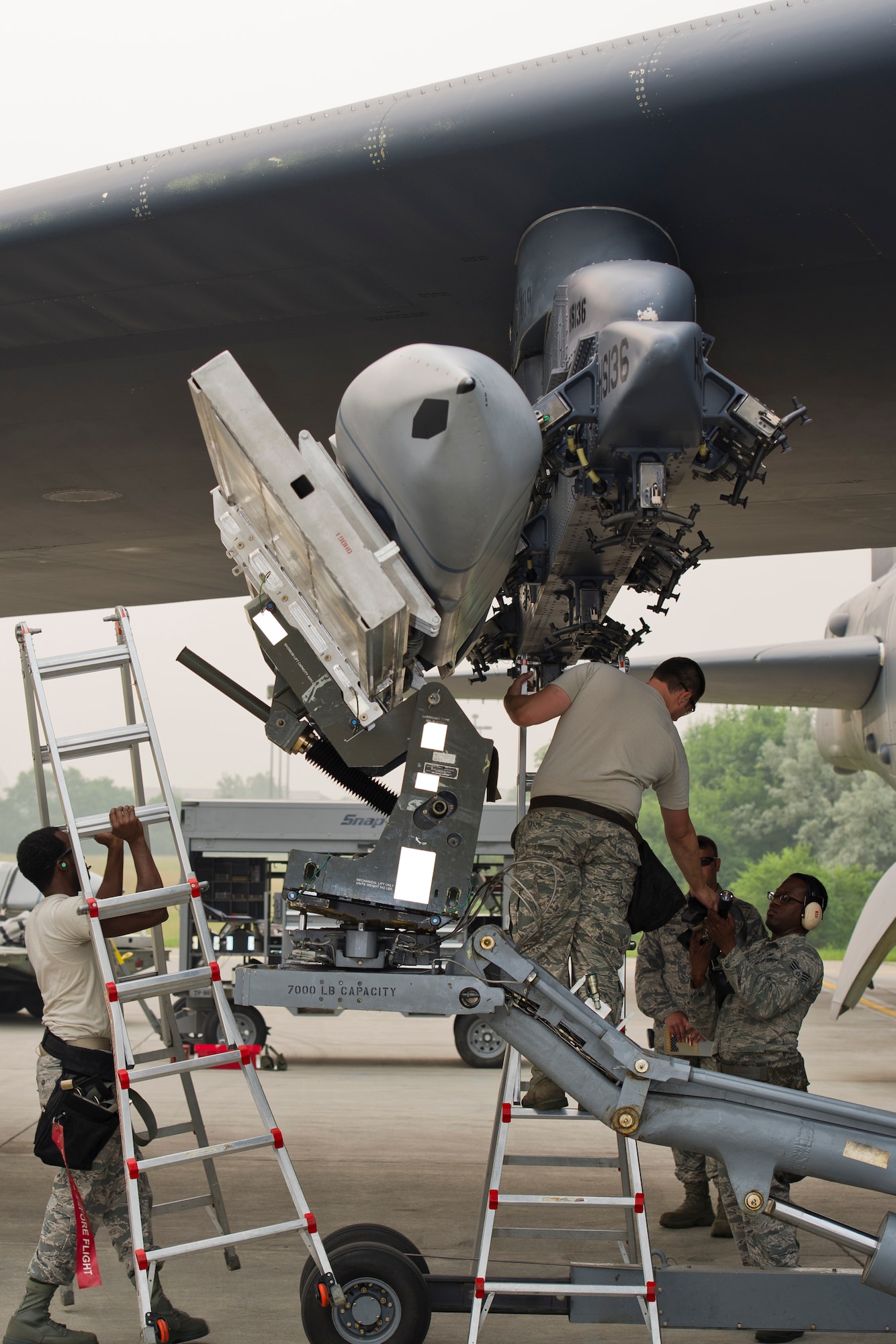 Airmen from the 5th Aircraft Maintenance Squadron load the first of two inert AGM-158 missiles onto the bomb rack of a B-52H Stratofortress during the Load Crew of the Quarter competition at Minot Air Force Base, N.D., July 1, 2015.  Staff Sgt. Demeterius White (left), a 5th Aircraft Maintenance Squadron load crew chief, directed the team during the missile load.  (U.S. Air Force photo/ Airman 1st Class Justin T. Armstrong)
