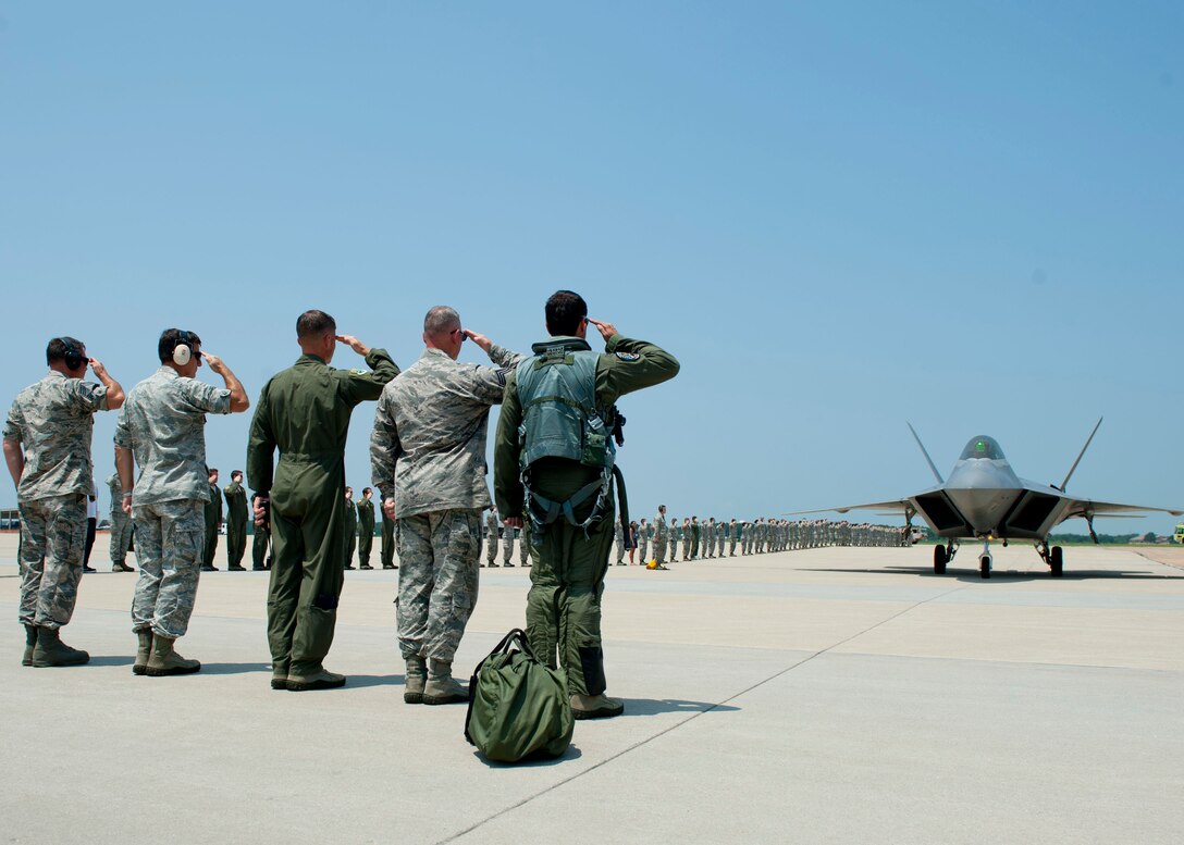 Members of the 1st Fighter Wing leadership team salute Brig. Gen. Kevin Huyck, 1st Fighter Wing commander as he taxis the F-22A Raptor during his fini flight at Langley Air Force Base, Va., July 7, 2015. During his time at the 1st FW, Huyck oversaw 1,400 personnel, two airfields, two groups and six squadrons, including two F-22 fighter squadrons and a T-38 Adversary Air Detachment. (U.S. Air Force photo by Staff Sgt. John D. Strong II)
