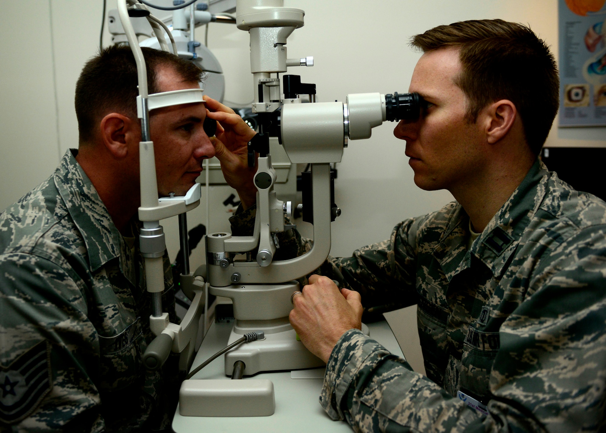 U.S. Air Force Capt. Sean Berensen, 31st Aerospace Medicine Squadron optometrist, examines the eyes of Tech. Sgt. Joel Ives, 31st AMDS optometry NCOIC, July 7, 2015, at Aviano Air Base, Italy. The optometry clinic conducts 300 eye exams every month. They check for any changes in each patient’s eyesight and perform procedures to identify any diseases a patient may have at the earliest stage possible. (U.S. Air force photo by Senior Airman Areca T. Wilson/Released)
