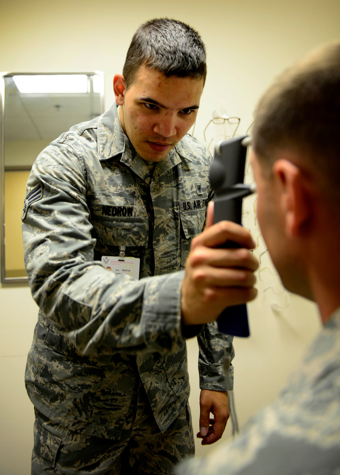 U.S. Air Force Senior Airman Joshua Nedrow, 31st Aerospace Medicine Squadron optometry technician, measures the intraocular pressure of a patient, July 7, 2015, at Aviano Air Base, Italy. In addition to performing routine exams, the optometry clinic offers eye glass and contact lens prescriptions. (U.S. Air force photo by Senior Airman Areca T. Wilson/Released)