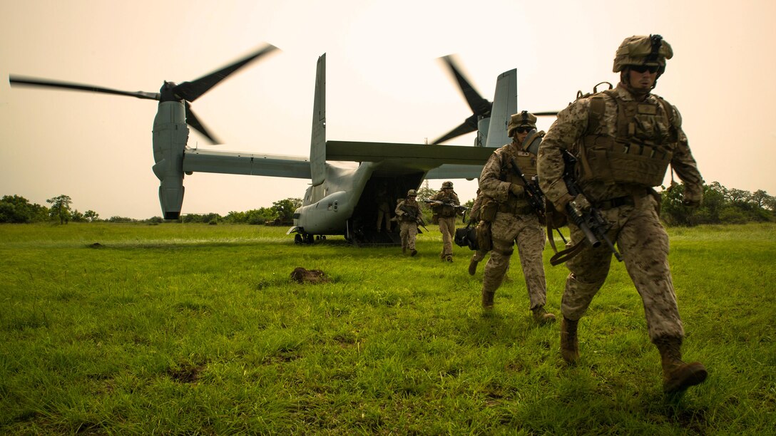 U.S. Marine Lance Cpl. Joshua Ewald, right, a member of Special-Purpose Marine Air-Ground Task Force Crisis Response-Africa, runs off an MV-22B Osprey during a training mission outside Accra, Ghana, April 13, 2015. The Marines used the vertical landing capabilities of the Osprey to secure a landing zone at their training site before securing a series of nearby compounds. 