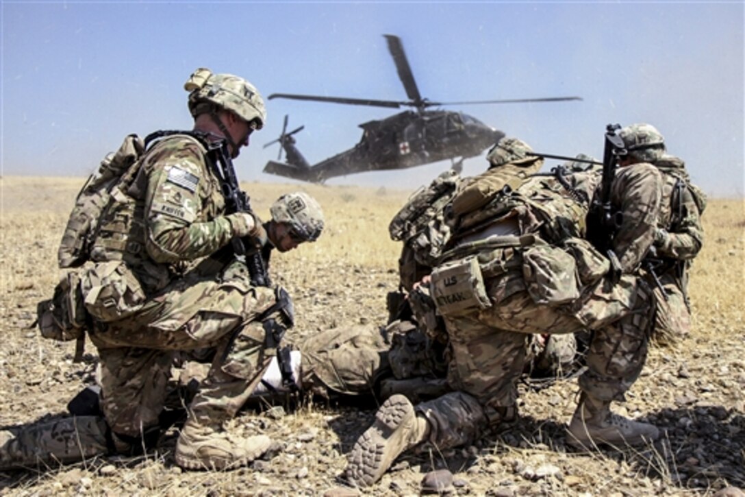 U.S. soldiers prepare a simulated casualty for transport as a UH-60 Black Hawk medevac helicopter lands near a live-fire exercise on Tactical Base Gamberi, Afghanistan, July 3, 2015. The soldiers are assigned to the 101st Airborne Division's 3rd Brigade Combat Team.
