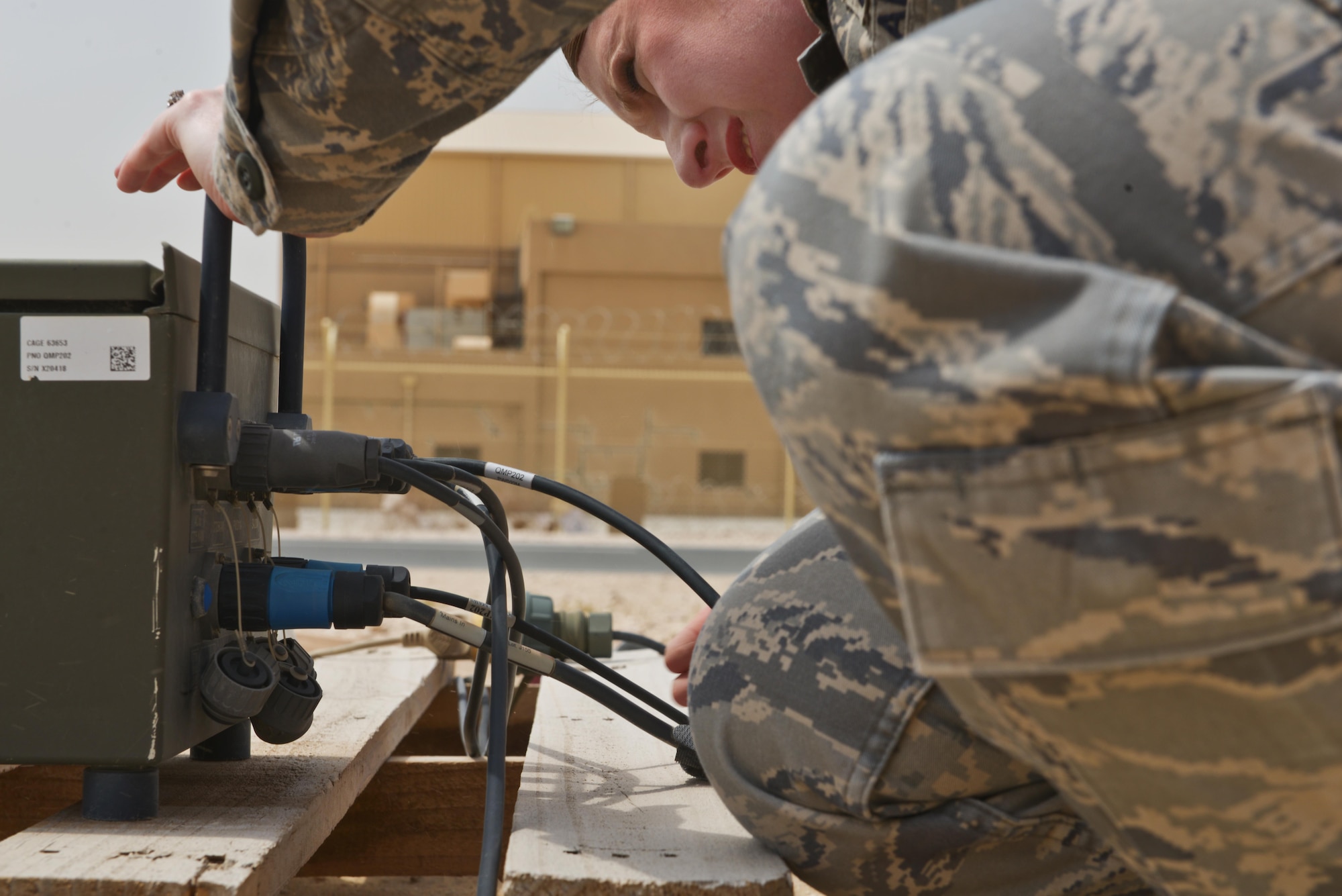 Tech. Sgt Vanessa Gonzales, 379th Expeditionary Operations Support Squadron weather forecaster, ensures connections are stable on a Tactical Meteorological Observing Sensor module July 8, 2015 Al Udeid Air Base, Qatar.  