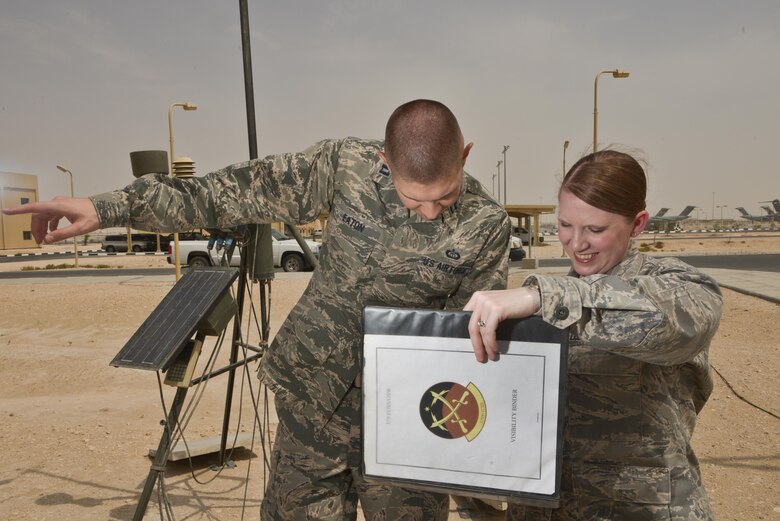 Capt. Kevin Eaton and Tech. Sgt Vanessa Gonzales, 379th Expeditionary Operations Support Squadron, check visibility charts with landmarks to update flying operation squadrons and security personnel July 8, 2015 Al Udeid Air Base, Qatar.  