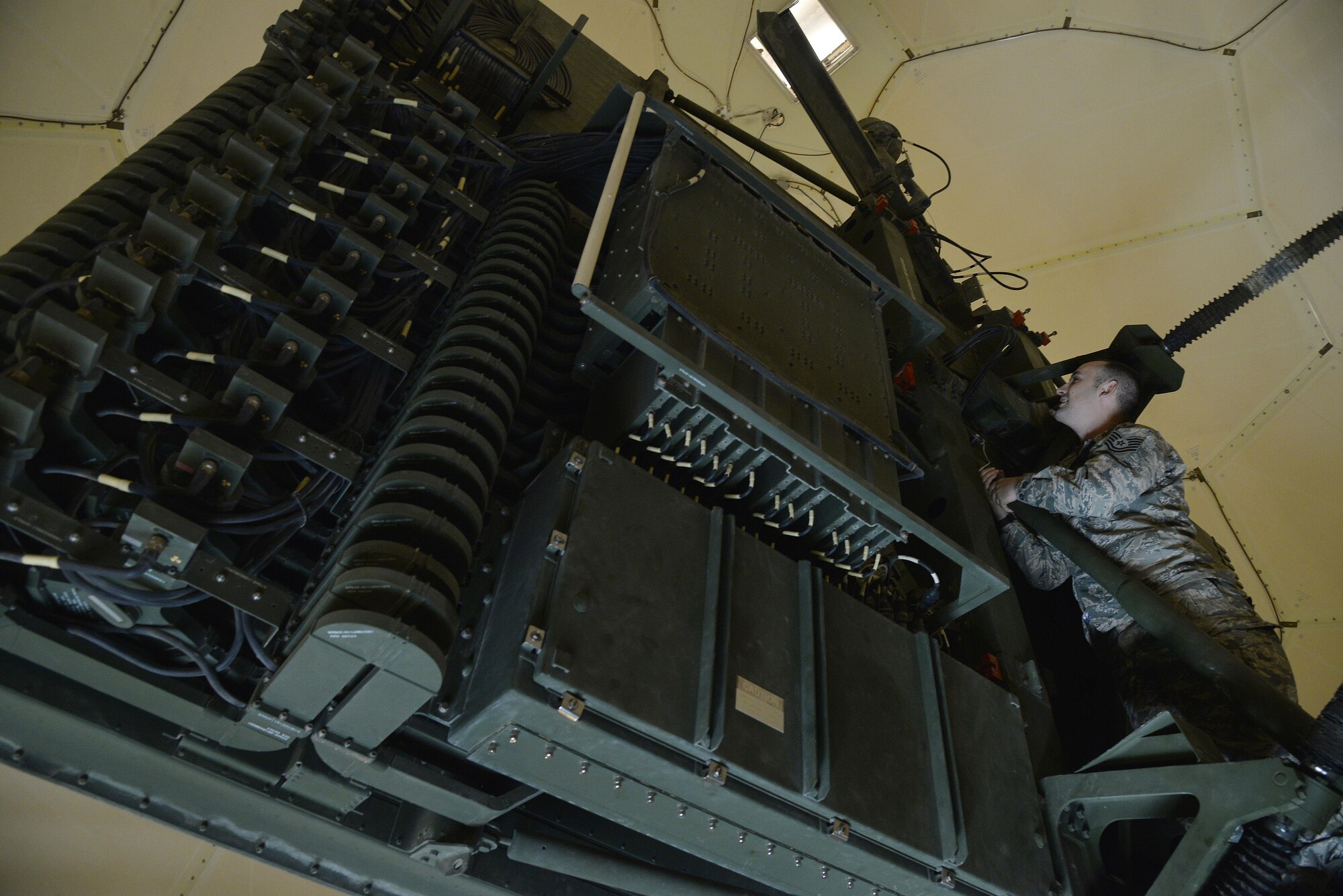 Tech. Sgt. Jonathan performs a visual inspection for corrosion prior to cleaning and lubricating the TPS-75 radar antenna at an undisclosed location in Southwest Asia June 29, 2015. Sgt. Jonathan is a radar craftsman assigned to the Expeditionary Air Control Squadron. (U.S. Air Force photo/Tech. Sgt. Christopher Boitz)