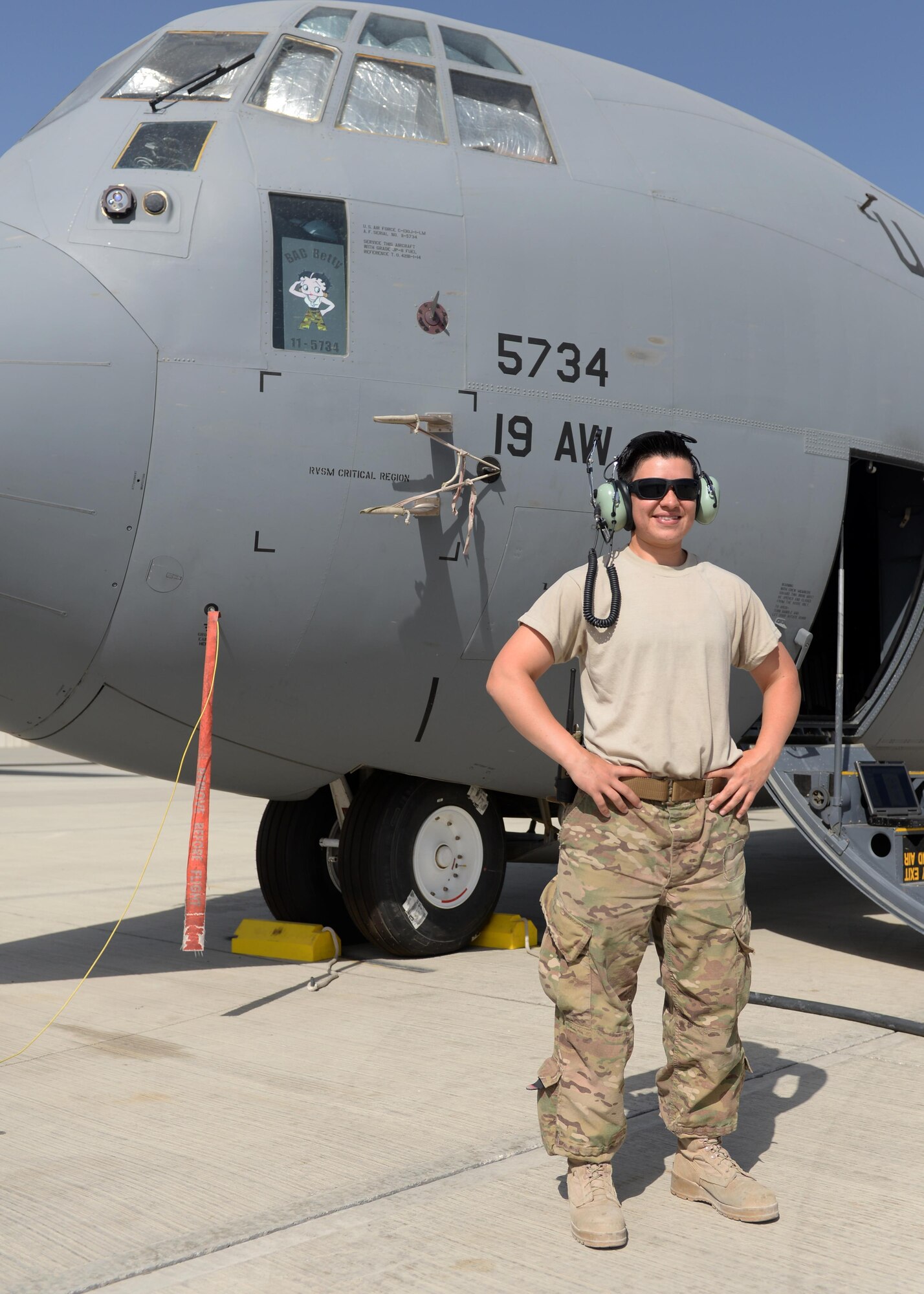 U.S. Air Force Staff Sgt. Danielle Garcia, 455th Expeditionary Aircraft Maintenance Squadron instruments and flight controls systems technician, poses for a photo by a C-130J Super Hercules aircraft July 9, 2015, at Bagram Airfield, Afghanistan. Garcia is responsible for ensuring the flight controls and navigational systems for the C-130J are updated and operational. (U.S. Air Force photo by Senior Airman Cierra Presentado/Released)