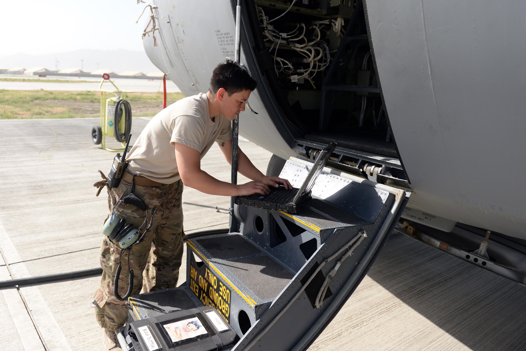 U.S. Air Force Staff Sgt. Danielle Garcia, 455th Expeditionary Aircraft Maintenance Squadron instruments and flight controls systems technician, loads data onto a laptop for a C-130J Super Hercules aircraft flight controls system July 9, 2015, at Bagram Airfield, Afghanistan. Garcia is responsible for ensuring the flight controls and navigational systems for the C-130J are updated and operational. (U.S. Air Force photo by Senior Airman Cierra Presentado/Released)