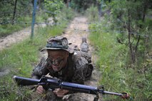 An Officer Candidate negotiates a wire obstacle in the woods of Quantico during a Small Unit Leader Evaluation exercise at Officer Candidate School. The purpose of the exercise is to test individual candidates on their ability to not only lead, but to motivate and confidently accomplish the mission with their unit while in a chaotic environment.