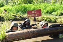 Officer Candidates test their courage, commitment and motivation as they navigate through the infamous Quigley water obstacle course at Officer Candidates School in Quantico, Virginia. The Quigley consists of a long canal with barbed wire and three 4-foot cement culverts submerged in swampy, snake-infested water that candidates must swim through as a part of the OCS training program.