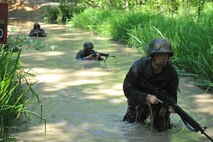 Officer Candidates test their courage, commitment and motivation as they navigate through the infamous Quigley water obstacle course at Officer Candidates School in Quantico, Virginia. The Quigley consists of a long canal with barbed wire and three 4-foot cement culverts submerged in swampy, snake-infested water that candidates must swim through as a part of the OCS training program.