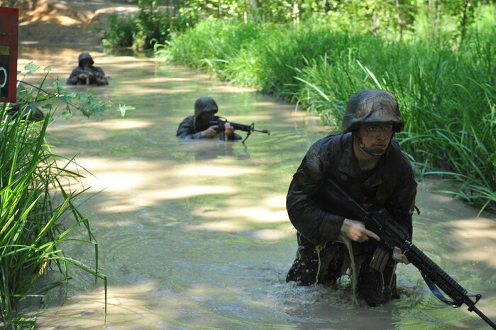 Officer Candidates test their courage, commitment and motivation as they navigate through the infamous Quigley water obstacle course at Officer Candidates School in Quantico, Virginia. The Quigley consists of a long canal with barbed wire and three 4-foot cement culverts submerged in swampy, snake-infested water that candidates must swim through as a part of the OCS training program.