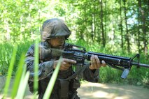 An Officer Candidate tests his courage, commitment and motivation as they navigate through the infamous Quigley water obstacle course at Officer Candidates School in Quantico, Virginia. The Quigley consists of a long canal with barbed wire and three 4-foot cement culverts submerged in swampy, snake-infested water that candidates must swim through as a part of the OCS training program.