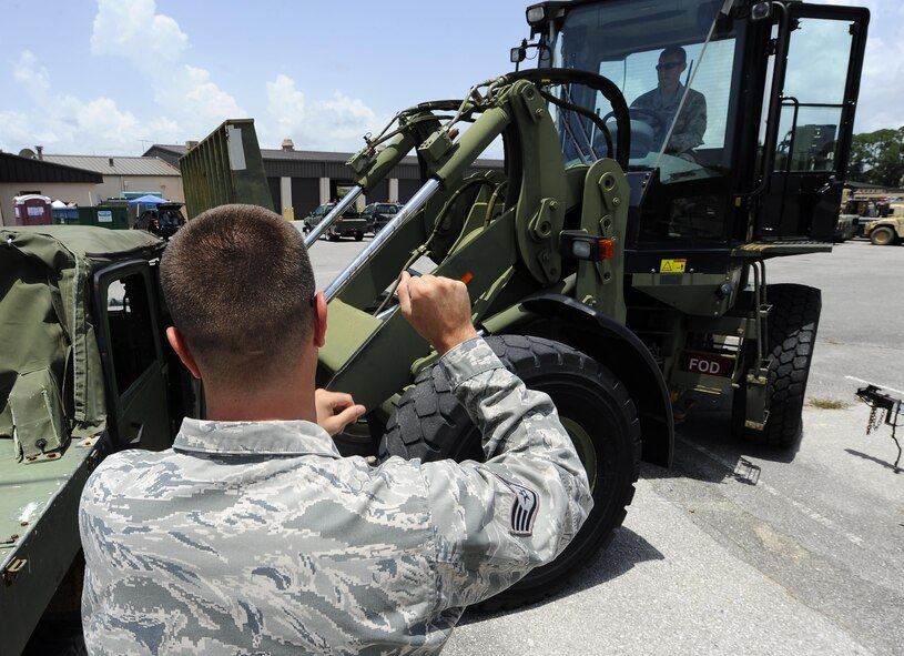 Staff Sgt. Jonathan New, 1st Special Operations Logistics Readiness Squadron vehicle operator, directs Senior Airman Daniel Dennison, 1 SOLRS vehicle operator, as he lifts a Humvee at Hurlburt Field, Fla., July 7, 2015. The Vehicle Operations flight is composed of 35 Airmen who issue government licenses and are responsible for more than 75 vehicles used for flightline operations, cargo movement, base taxi services and temporary duty Airmen at Hurlburt Field. (U.S. Air Force photo/Senior Airman Andrea Posey)