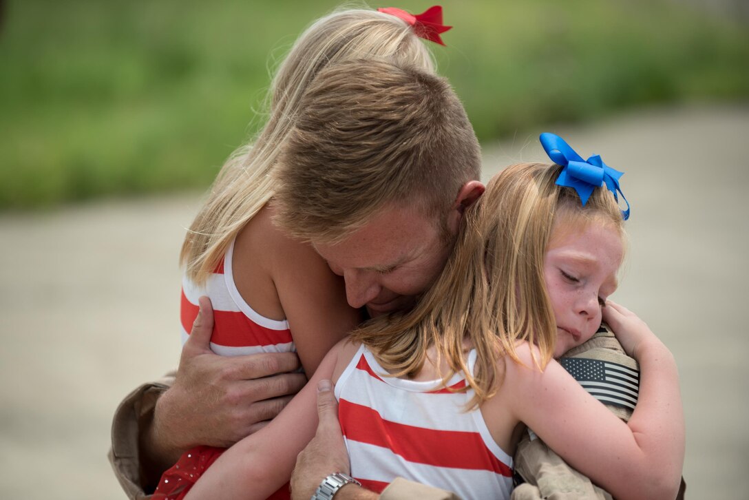 Capt. Ross Farling, a C-130 Hercules pilot from the 123rd Airlift Wing, hugs his daughters during a homecoming ceremony at the Kentucky Air National Guard Base in Louisville, Ky., July 4, 2015. Farling was among 39 guardsmen who returned from a deployment to the Persian Gulf region, where they supported Operation Freedom's Sentinel. (U.S. Air National Guard photo/Maj. Dale Greer)