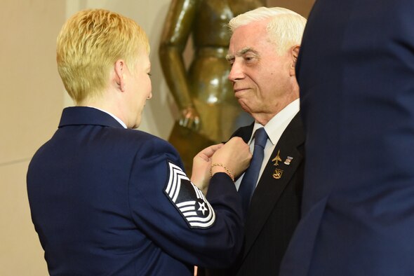 Chief Master Sgt. Nicole Johnson, the executive assistant to the chief master sgt. of the Air Force, presents the commemorative Vietnam veteran lapel pin to retired Col. Michael Brazelton during the Congressional Commemoration for the 50th Anniversary of the Vietnam War July 8, 2015, in the Emancipation Hall of the U.S. Capitol in Washington. (U.S. Air Force photo/Staff Sgt. Carlin Leslie)