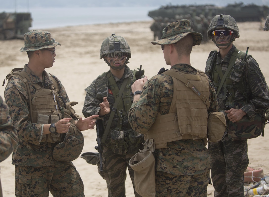 Lance Cpl. Paul J. Yi, chemical, biological, radiological and nuclear defense specialist with 4th Light Armored Reconnaissance Battalion, 4th Marine Division, translates for U.S. and Korean Marines before a beach assault during Peninsula Express 15 on Dogu beach in Pohang, Republic of Korea, July 3, 2015. Yi attached to Company G, 2nd Battalion, 24th Marine Regiment, as their interpreter for the training cycle. Peninsula Express is this year’s eighth iteration of the Korean-Marine Exchange Program, a series of exercises between the U.S. and Republic of Korea Marine Corps designed to build interoperability and tactical familiarity between partner the nations. (U.S. Marine Corps photo by Cpl. Ian Leones)
