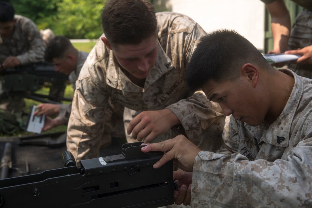 Artillerymen with 10th Marine Regiment work together to assemble small crew-served weapons during the Super Section Competition aboard Camp Lejeune, N.C., June 30 through July 1, 2015. Five gun sections from the regiment built cohesion and competed in timed knowledge events, a nine-mile hike, a three-mile endurance course through swamp water and a direct-fire range. (U.S. Marine Corps photo by Lance Cpl. Fatmeh Saad/Released)