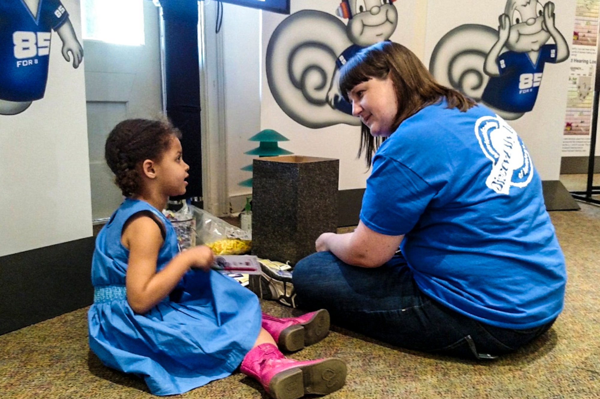 Dr. Denise Thomas, audiologist, explains strategies to prevent hearing loss to Sadie, 4, daughter of Maj. Kwame Curtis, Hearing Center of Excellence Air Fore liaison at a local museum, March 29, 2015. (Courtesy photo)