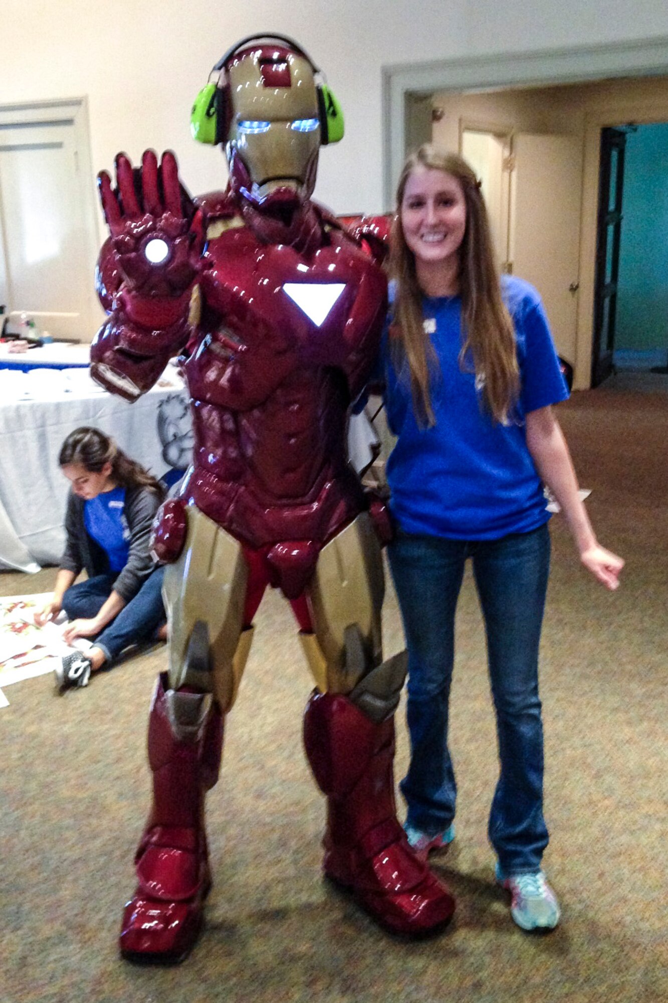 Brittany Swiger, Hearing Center of Excellence research assistant, poses with Iron Man, at a local museum, March 29, 2015. Iron Man was supporting a child who previously did not like to wear his cochlear implants because his favorite superheroes did not have them. Sporting some bright, fluorescent ear muffs, Iron Man demonstrated how hearing protection was necessary and could be cool. (Courtesy photo)