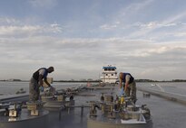 Staff Sgt. Anthony McCullan and Senior Airman Johnathan Morgan, 1st Special Operations Logistics Readiness Squadron fuel laboratory technicians, take samples from a fuel delivery barge at Hurlburt Field, Fla., June 25, 2015. For every fuel delivery, fuels Airmen conduct quality control tests to ensure the Air force is receiving the proper grade and amount of fuel. (U.S. Air Force photo /Airman Kai White/Released)
