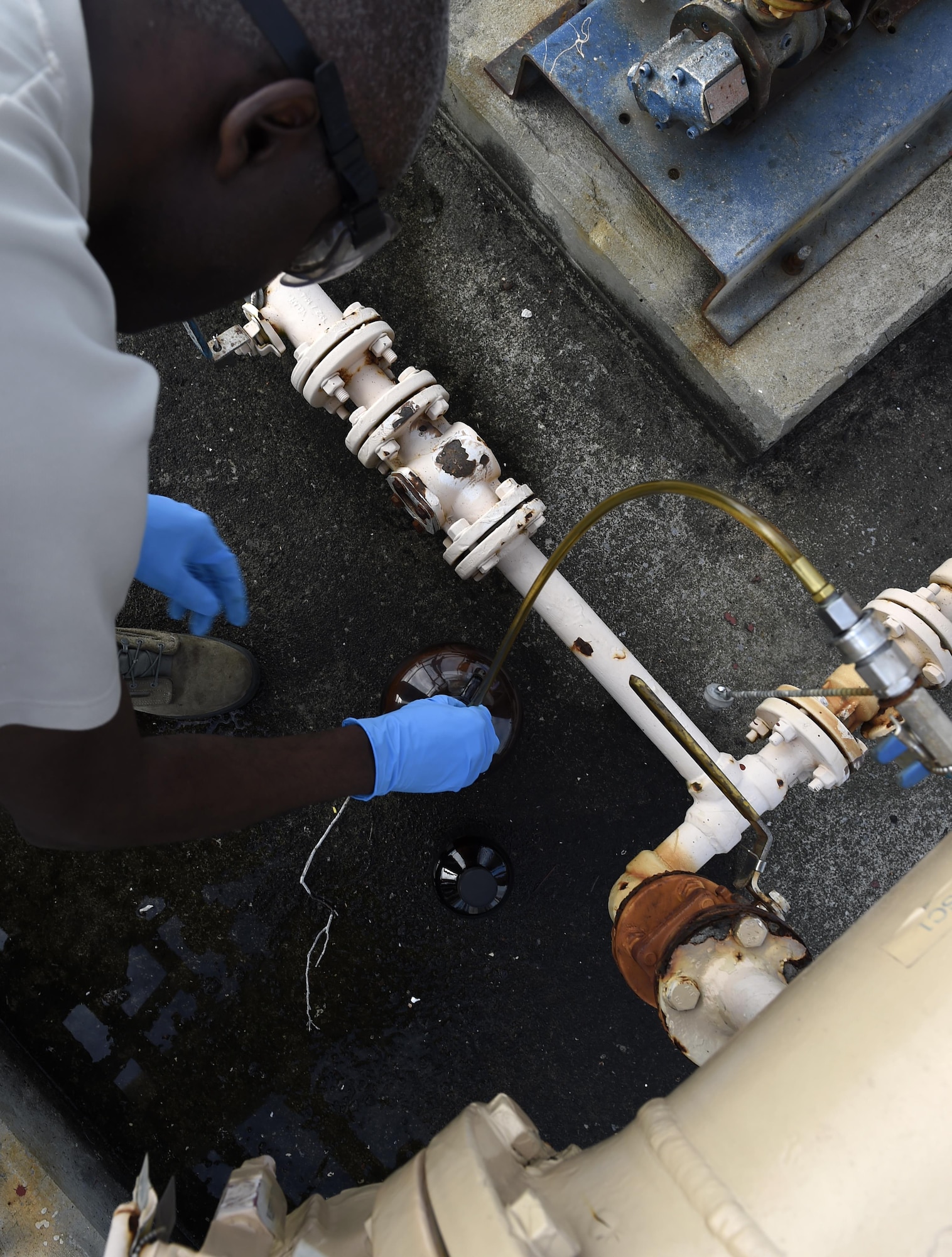 Staff Sgt. Anthony McCullan, 1st Special Operations Logistics Readiness Squadron fuels laboratory technician NCO in charge, takes fuel from a sample line at Hurlburt Field, Fla., June 25, 2015. Samples are taken to verify quality assurance of the fuel. (U.S. Air Force photo/Airman Kai White/Released)