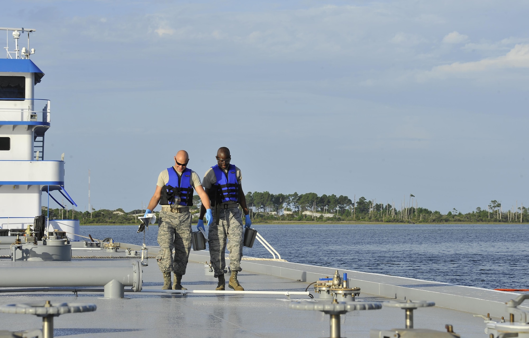 Senior Airman Johnathan Morgan and Staff Sgt. Anthony McCullan, 1st Special Operations Logistics Readiness Squadron fuel laboratory technicians, collect fuel samples to be tested at Hurlburt Field, Fla., June 25, 2015. For every fuel delivery, fuels Airmen conduct quality control tests to ensure the Air force is receiving the proper grade and amount of fuel. (U.S. Air Force photo /Airman Kai White/Released)