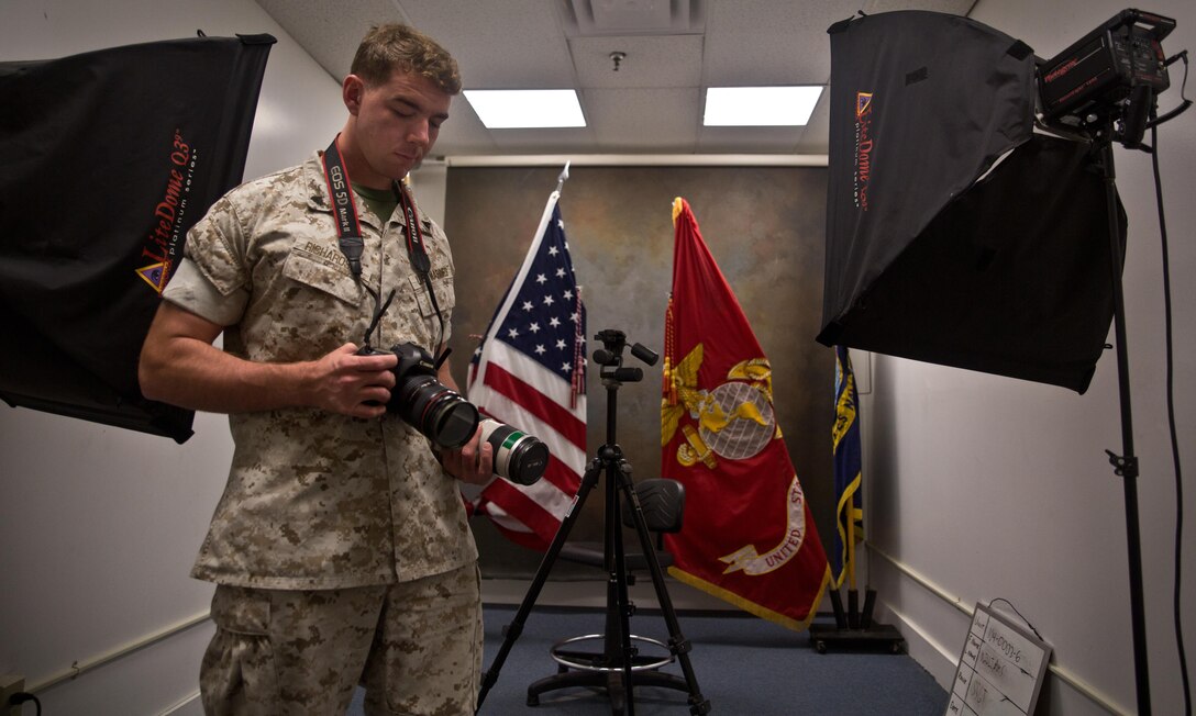 Cpl. Michael Richardson inspects a camera in the combat camera studio for promotion warrants. Originally he was a cannoneer with 1st Battalion, 12th Marine Regiment but is now serving as a studio clerk with Combat Camera due to the Fleet Assistance Program.