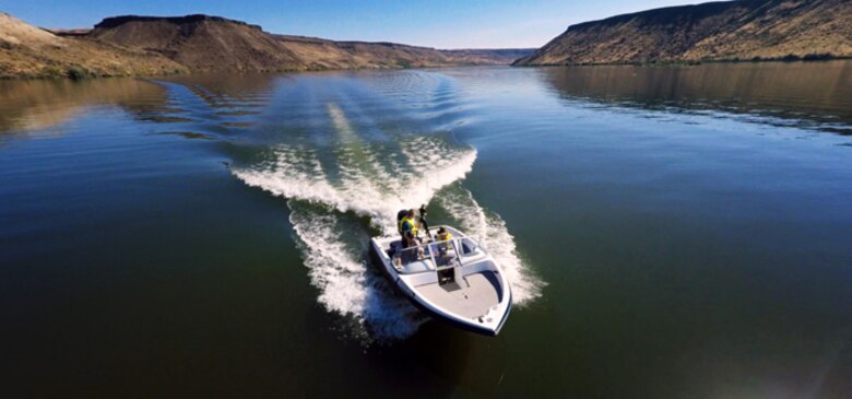 Senior Airman Jaye Legate, 366th Fighter Wing Public Affairs broadcaster, drives a ProCraft towing boat at C.J. Strike Reservoir, Idaho, June 26, 2015. The Air Force Marina at C.J. Strike Dam offers many rental options such as paddleboards, kayaks and various types of boats. (Courtesy photo by Samuel Morse)