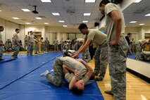 Senior Airman Collin Madison, 47th Security Forces Squadron patrolman, applies ‘a side-mount lockdown’ to Senior Airman Taylor Dempsey, 47 SFS commander secretary, in Losano Fitness Center on Laughlin Air Force Base, Texas, July 10, 2015. Members demonstrated learned techniques during numerous full-minute drills to address physical timing. The principle of physical timing is to attack at the split second when weight, momentum, and strength are gathered for use against itself. (U.S. Air Force photo by Airman 1st Class Brandon May)(Released)