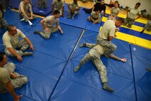 Master Sgt. Christopher Enfinger, 47th Security Forces Squadron assistant operations superintendent, demonstrates an ‘arm bar’ on Staff Sgt. Adam Wylie, 47 SFS training NCO in-charge, in Losano Fitness Center on Laughlin Air Force Base, Texas, July 10, 2015. Enfinger led the combatives course to ensure the ability of security forces personnel to tactfully and skillfully cope with situations which require the use of force in the control or restraint of personnel. (U.S. Air Force photo by Tech Sgt. Steven R. Doty)(Released)