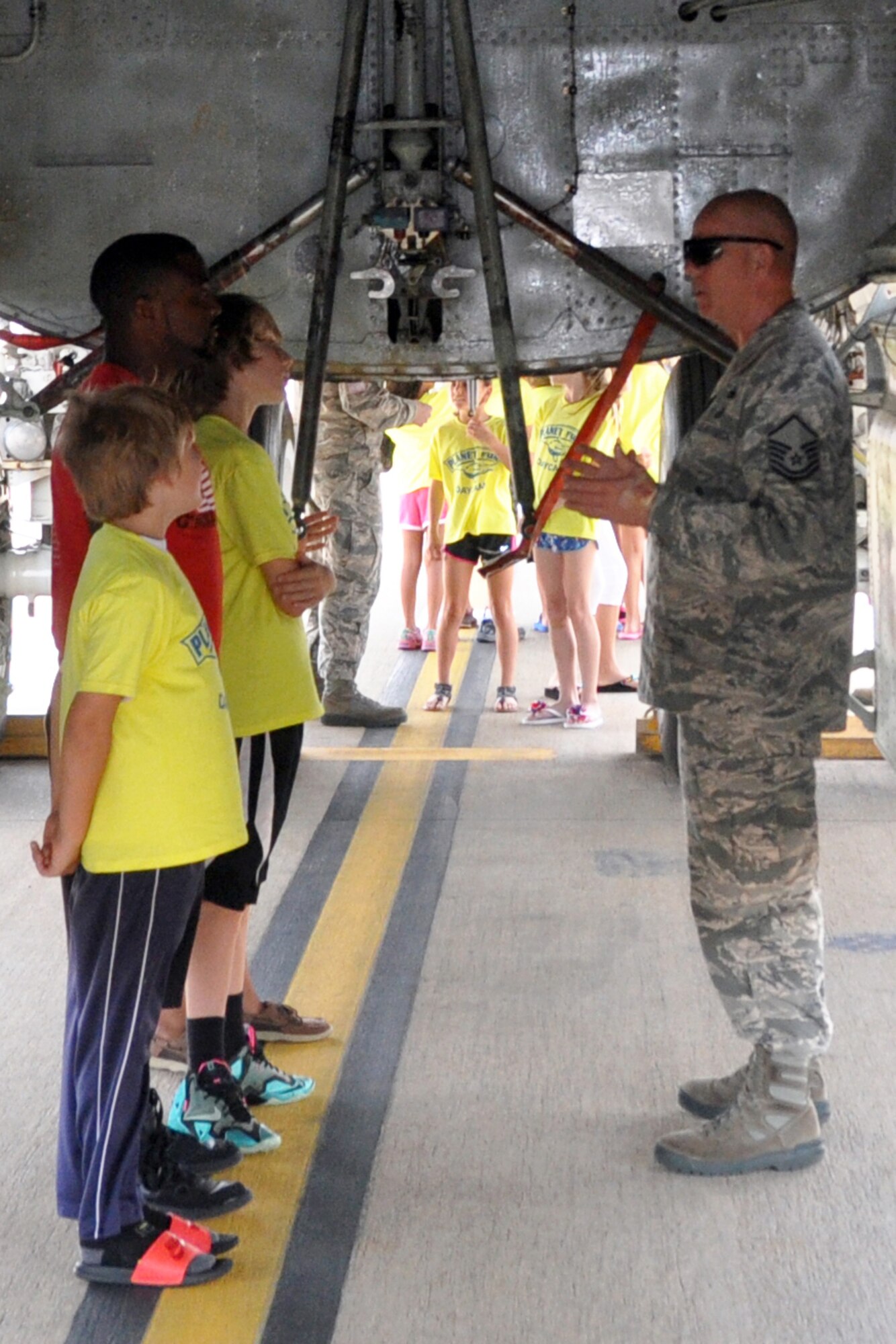 U.S. Air Force Master Sgt. Anthony Terral, 307th Bomb Wing Safety, explains the different kinds of munitions and how they are loaded in the bomb bay of a B-52 Stratofortress to participants of the Planet Fun summer camp during their tour of Barksdale Air Force Base, Louisiana, July 2, 2015. (U.S. Air Force photo by Master Sgt. Laura Siebert/Released)