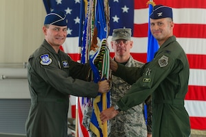 From left, U.S. Air Force Maj. Gen. H.D. Polumbo Jr., 9th Air Force commander, Chief Master Sgt. Emmette Bush, 1st Fighter Wing command chief, and Col. Pete Fesler, 1st FW incoming commander, pass a guidon during the 1st FW change of command ceremony at Langley Air Force Base, Va., July 10, 2015. After the passing of the guidon, Fesler assumed command of the wing after serving at the Pentagon as the Chief of Staff for the Joint Staff. (U.S. Air Force photo by Senior Airman Kimberly Nagle/Released)  