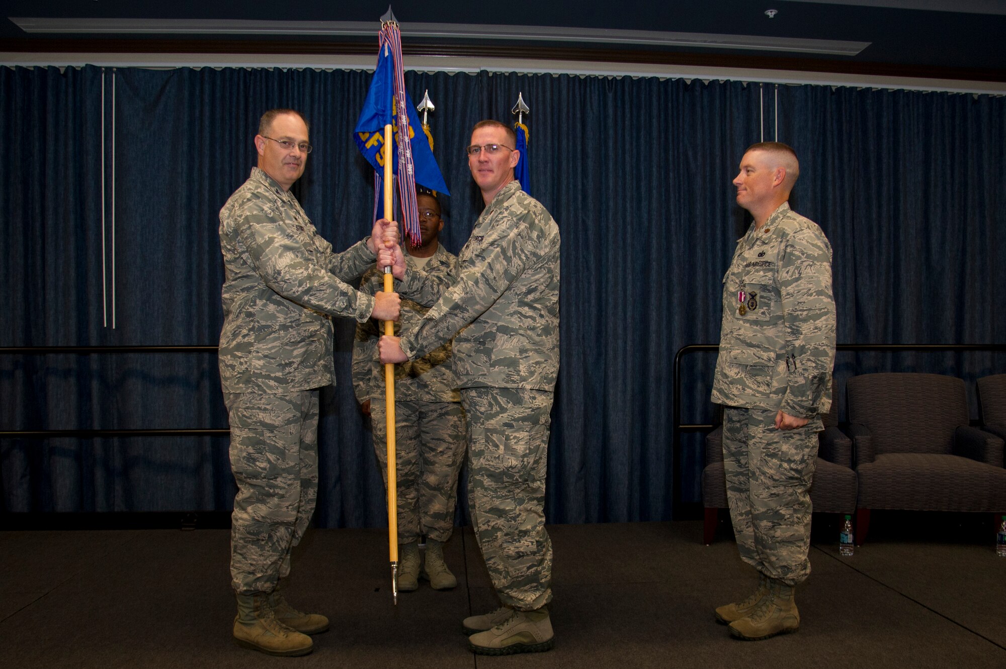 Col. David Stookey, 92nd Mission Support Group commander, gives the 92nd Security Forces Squadron guidon to Maj. Kevin A. McMahon, 92nd SFS commander, during the 92nd SFS change of command ceremony July 10, 2015, at Fairchild Air Force Base, Wash. The change of command ceremony is an official, formal and brief ceremony that is the military's way of bestowing command responsibility of a unit from one officer to another. (U.S. Air Force photo/Airman 1st Class Nicolo J. Daniello)