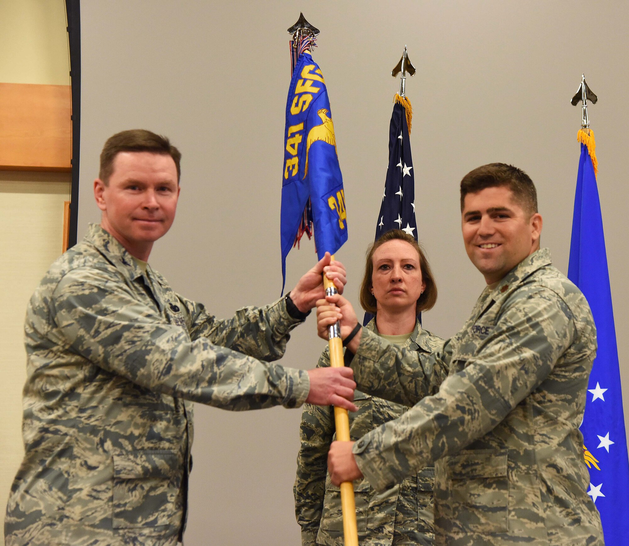 Maj. Jeremy Sheppard, right, accepts command of the 341st Missile Security Forces Squadron from Col. Kenneth O’Neil, 341st Security Forces Group commander, during a change of command ceremony at the Malmstrom Air Force Base Grizzly Bend July 10. Master Sgt. Micheal Filipovich, 341st MSFS first sergeant, looks on.  (U.S. Air Force photo/Airman 1st Class Collin Schmidt)